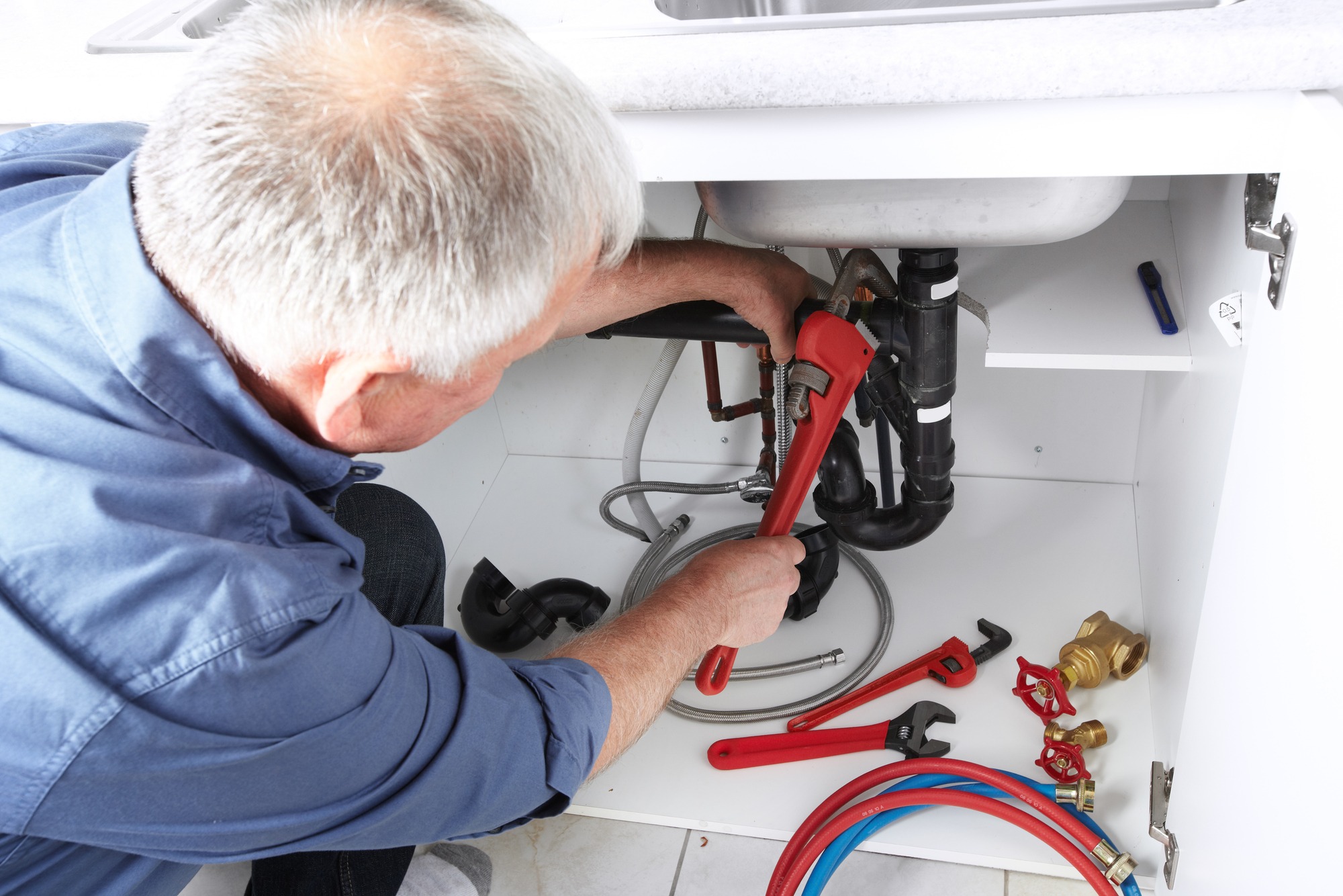 Hands of professional Plumber with a wrench