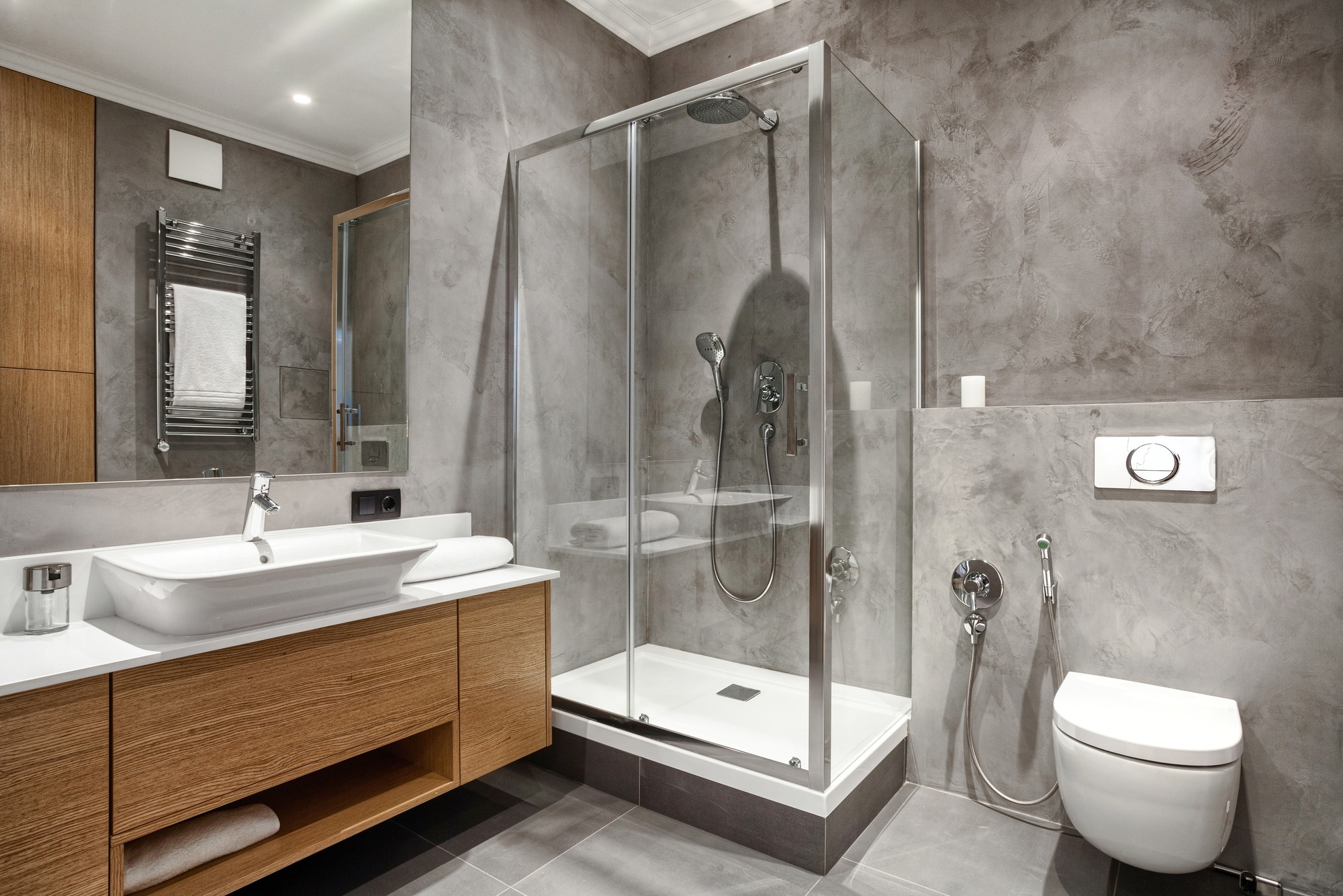 Modern bathroom featuring a glass shower, sleek vanity with a vessel sink, and neutral gray walls. Designed for contemporary aesthetics.