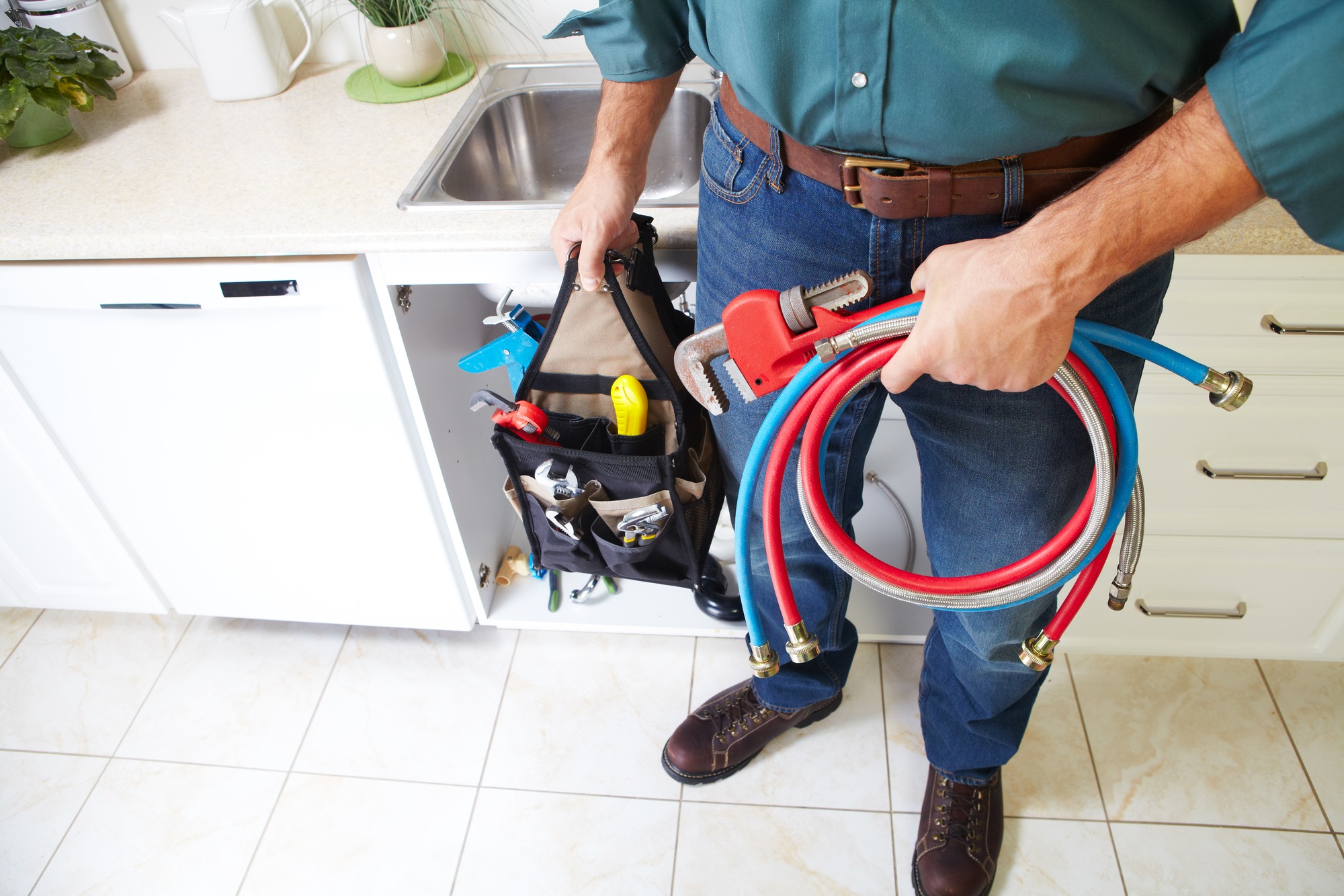 Plumber with Plumbing tools on the kitchen.